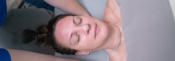 Woman with eyes closed, receiving massage therapy